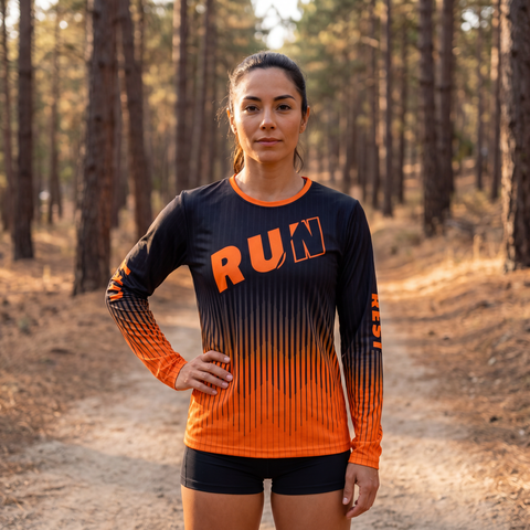 Female athlete wearing a black and orange RUN REST LIFT REPEAT long sleeve performance shirt outdoors